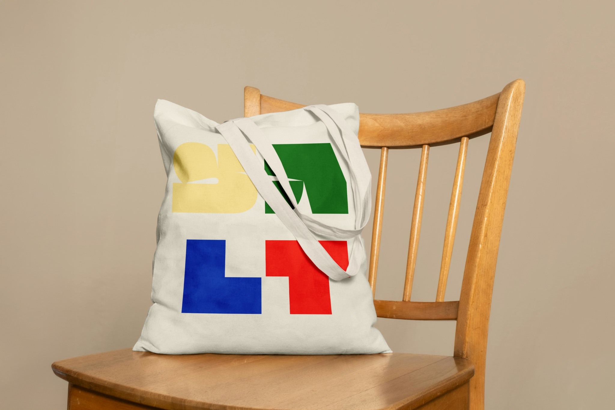 Light tote bag with colourful geometric forms on a wooden chair
