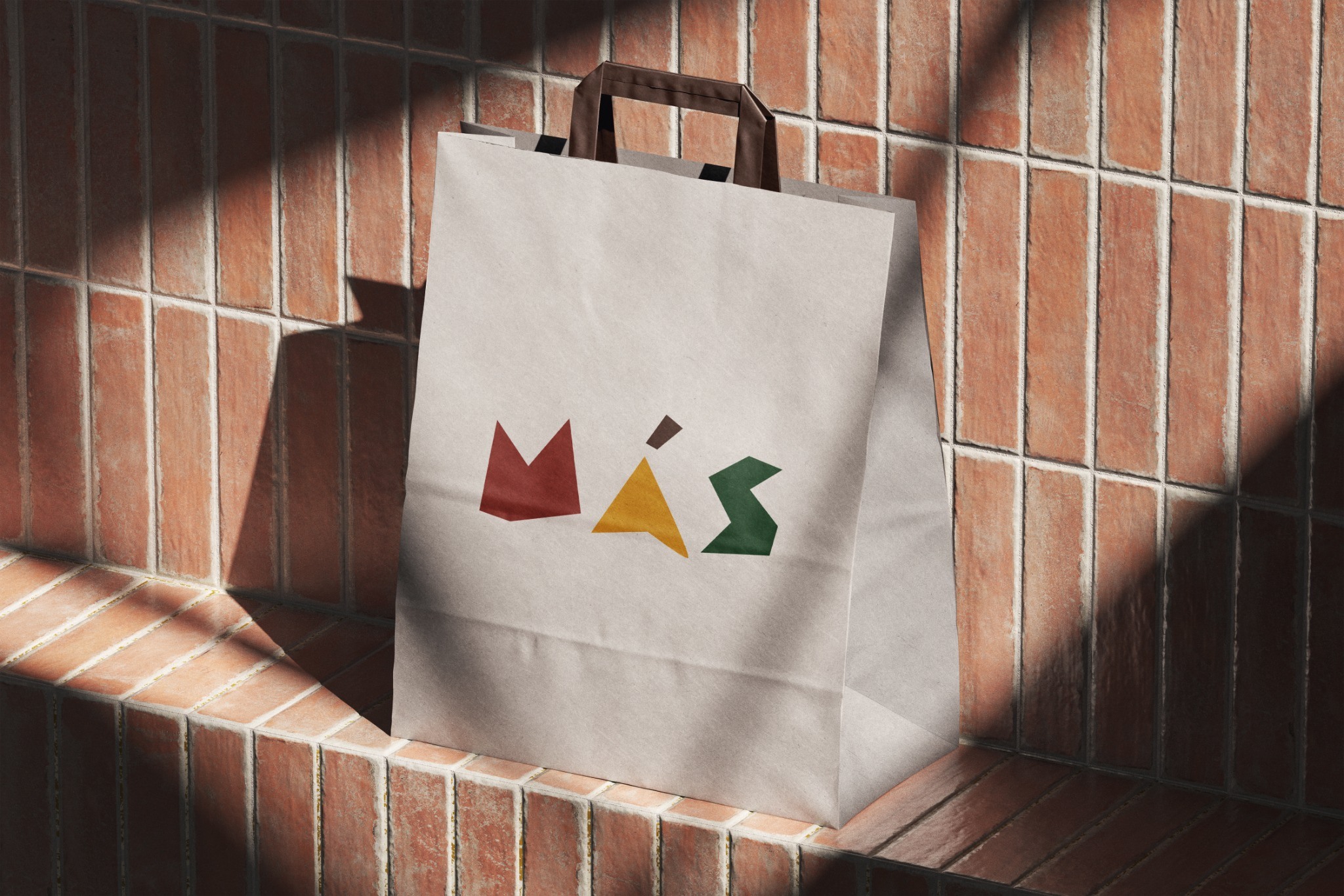 Light MAŚ shopping bag with colourful geometric lettering against brick architecture