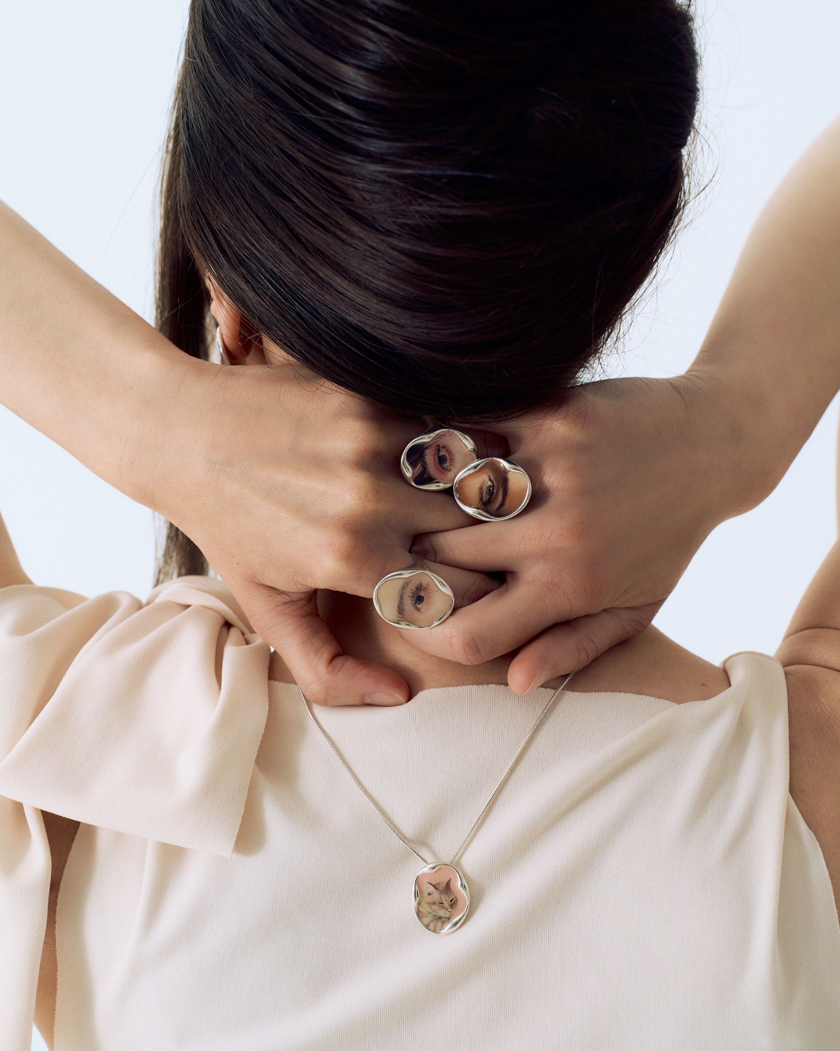 Eye portrait rings, earrings and a pendant seen from behind