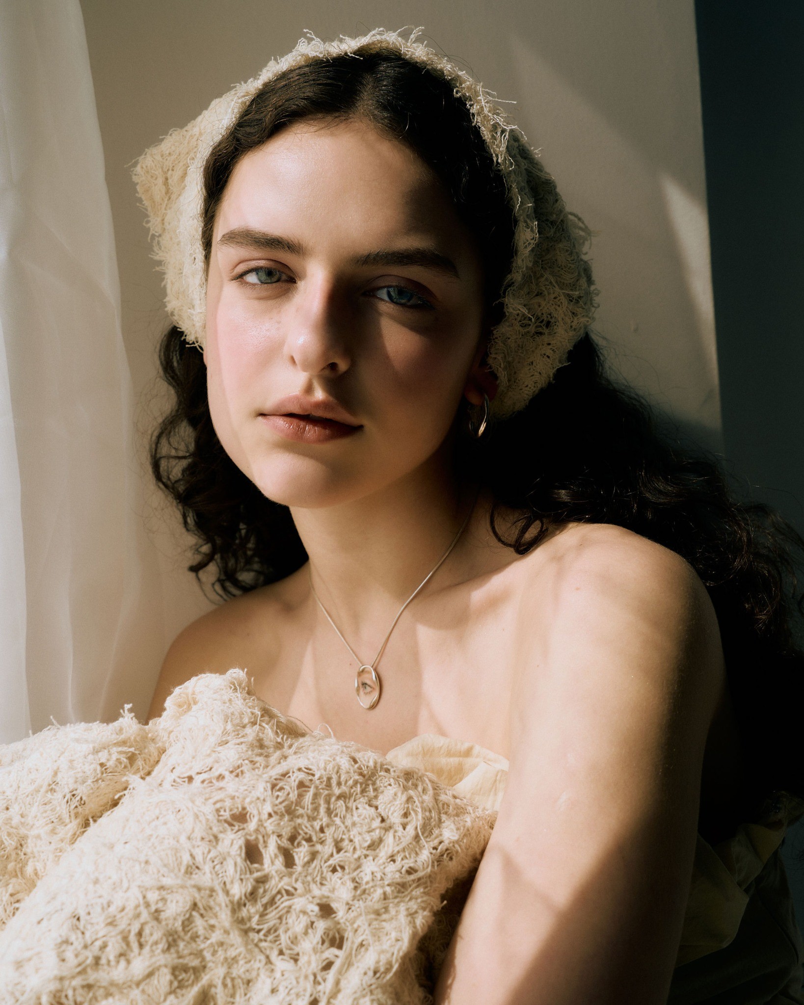 Portrait in natural light with a painted eye pendant