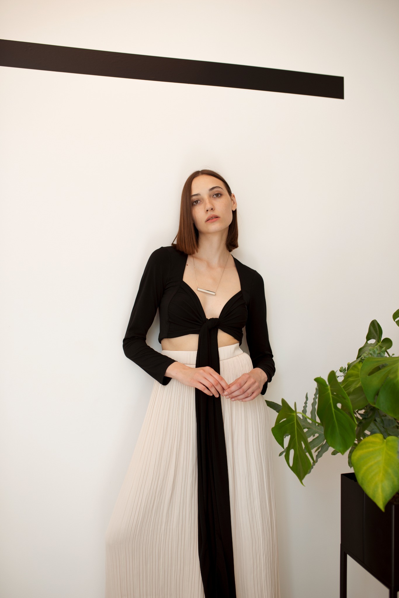 Long pendant worn with a black top and pale skirt
