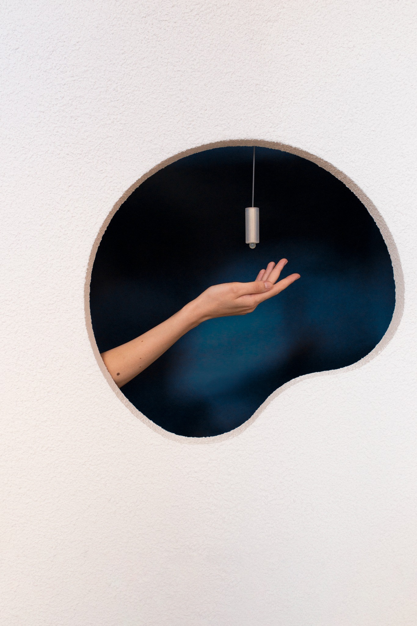 Pendant held above a hand in a mirror