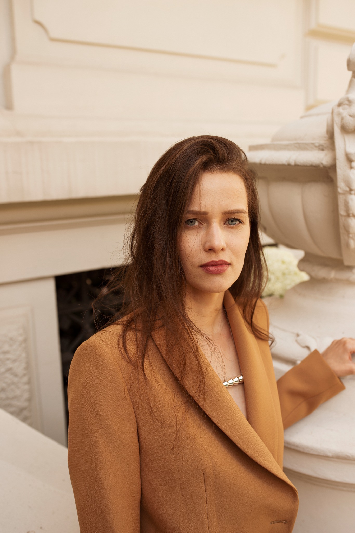 Silver jewelry worn with a warm brown jacket