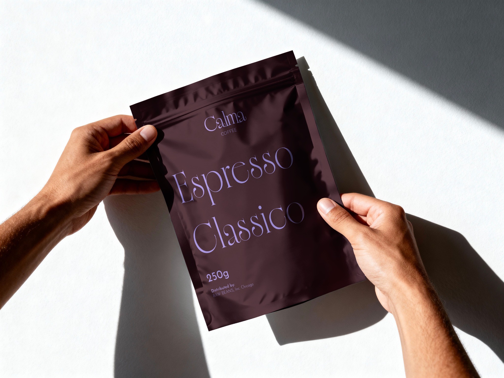 Dark Calma coffee bag held in two hands