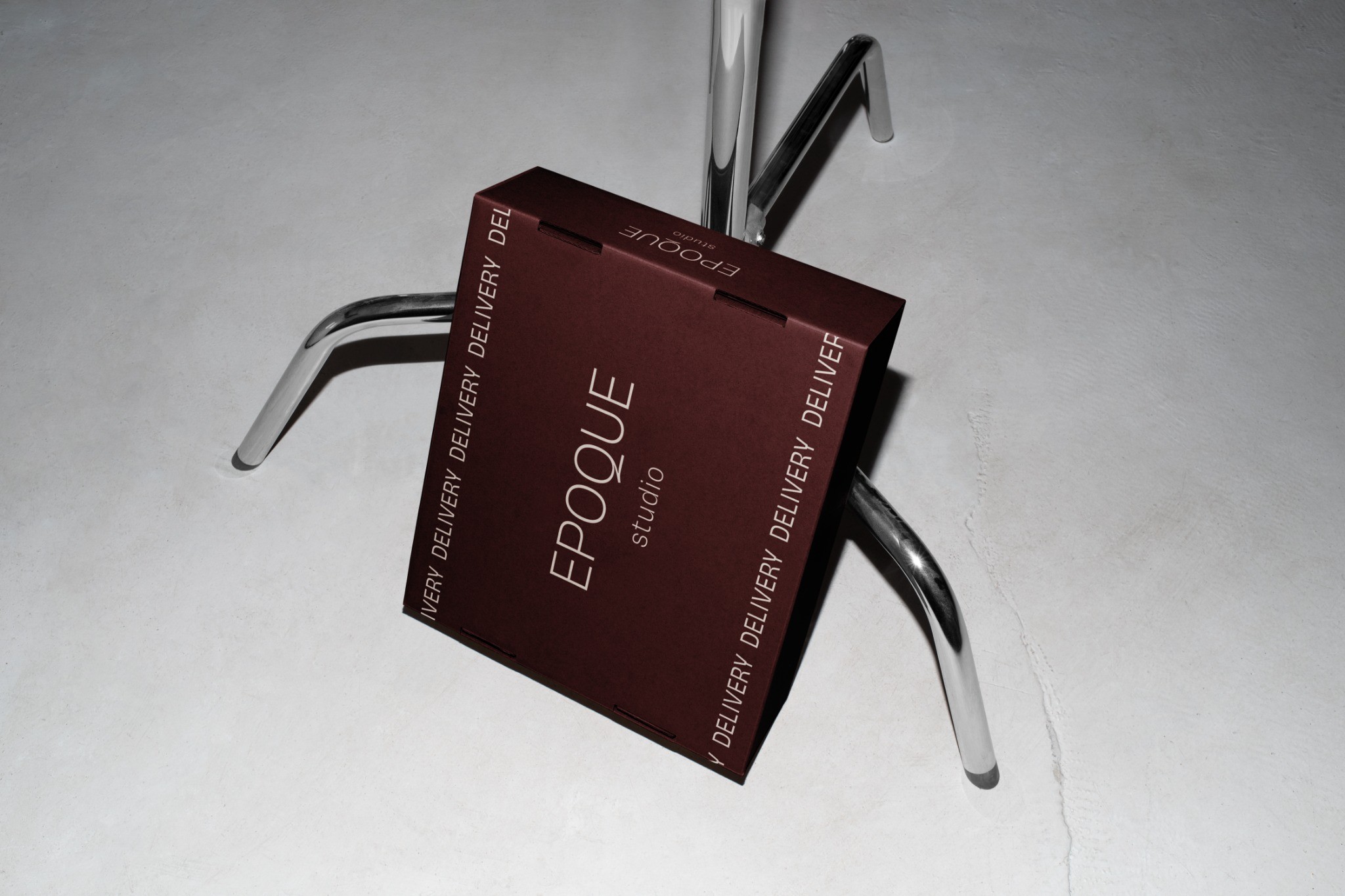 Burgundy Epoque Studio delivery box on a metal chair