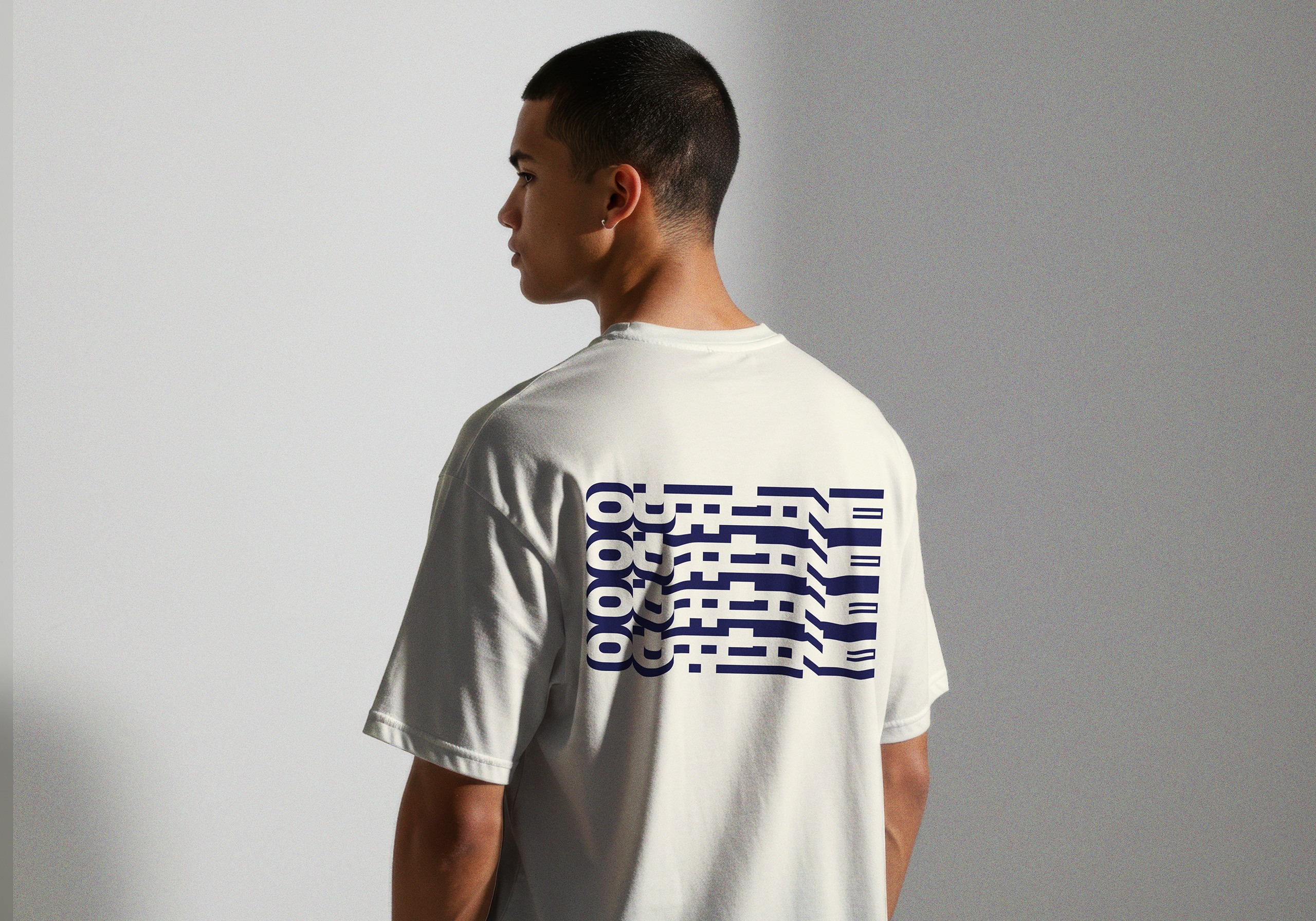 Repeated navy Outline graphic on the back of a cream T-shirt